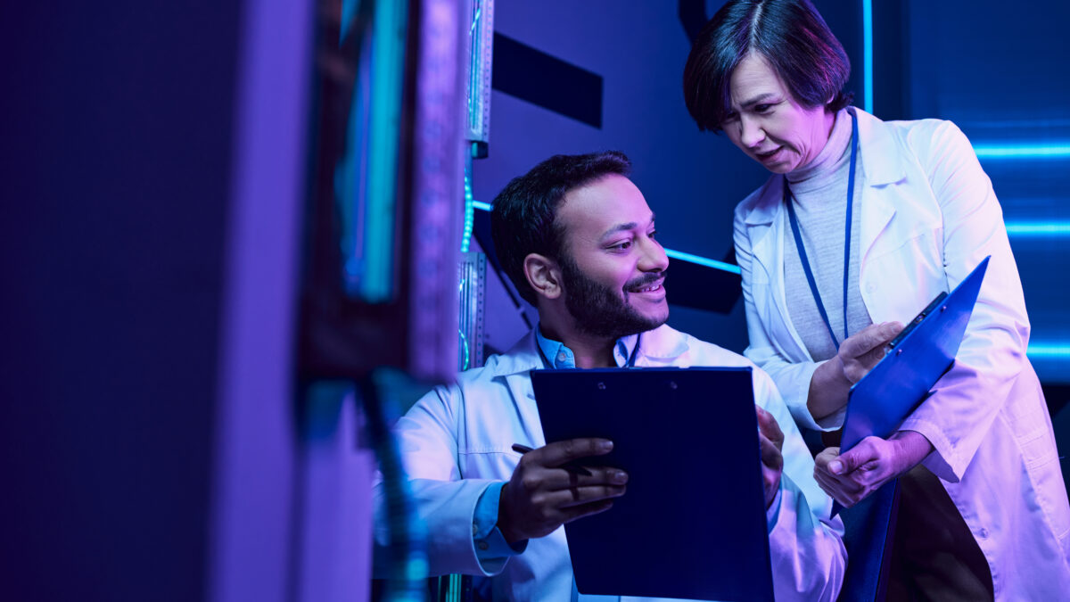 Futuristic Collaboration Hindu Male and Adult Female Scientists Analyze Data and Share Smiles - Alpha