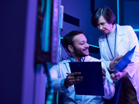 Futuristic Collaboration Hindu Male and Adult Female Scientists Analyze Data and Share Smiles - Alpha