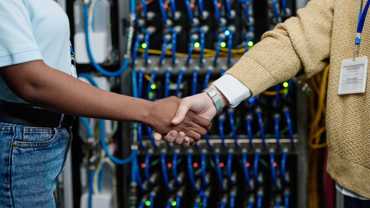 Engineers shaking hands in data center - Alpha